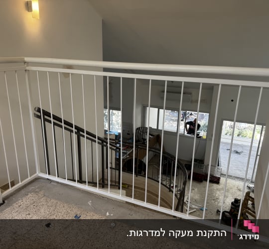 מעקה בטיחות ממתכת לבנה בגלריה פנימית ומעקה מתכת במדרגות